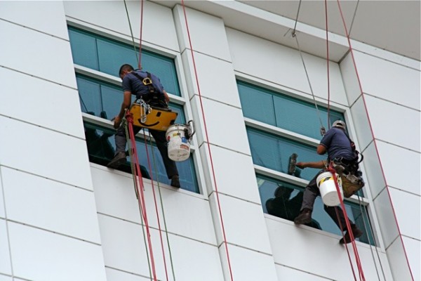 Two people cleaning a high-rise window