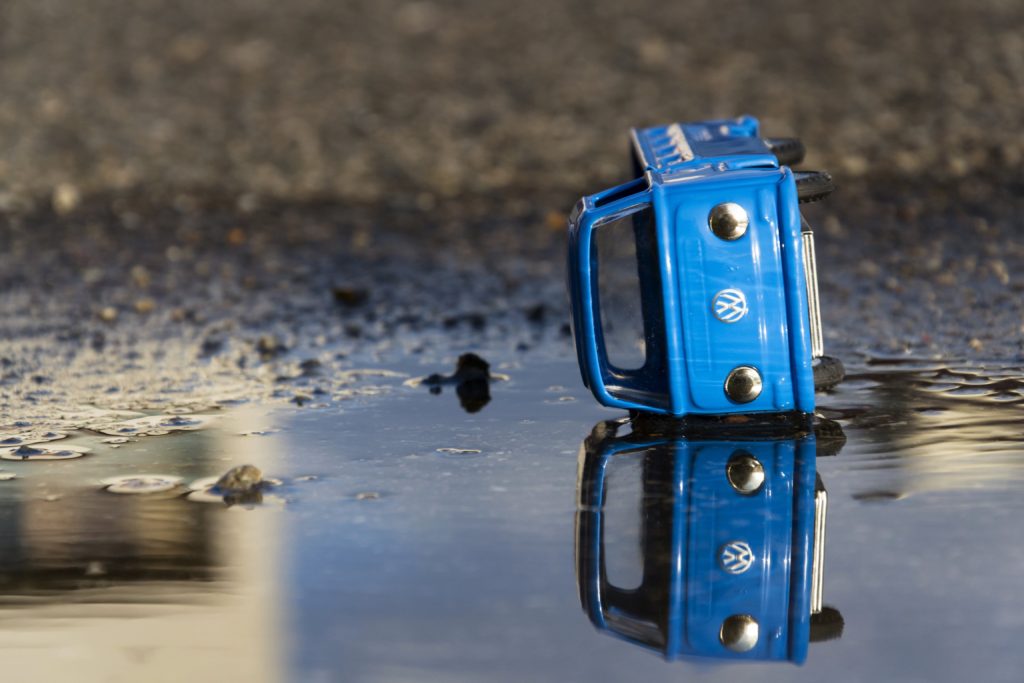 A Toy Car with Volkswagen Logo and Reflection in the Water
